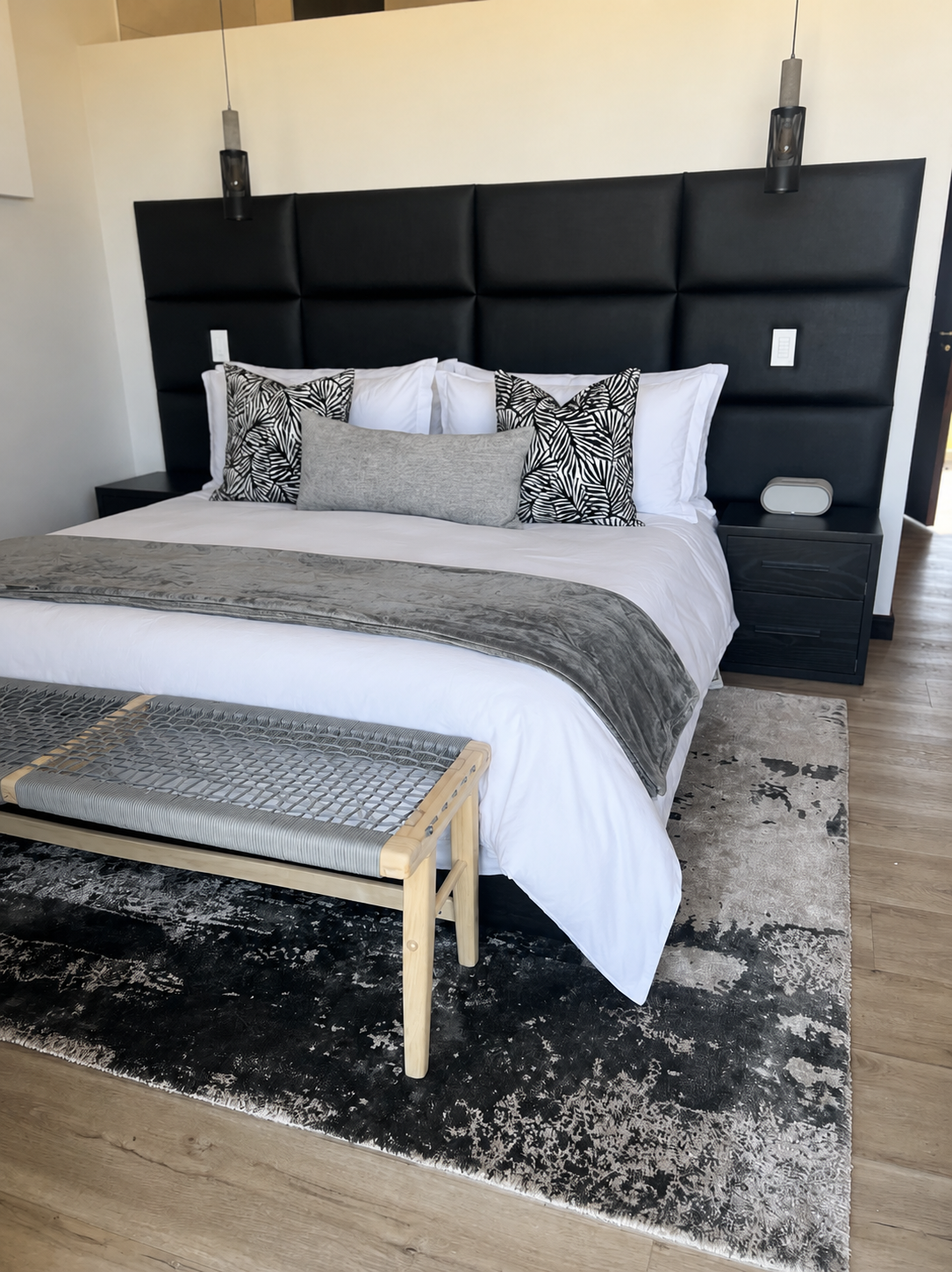 Oversized black panelled leather headboard with bespoke black bedside cabinets